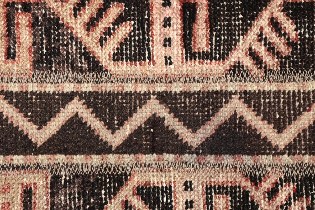 Detailed view of the zigzag and step motifs within the rug's pattern, with visible knotting.