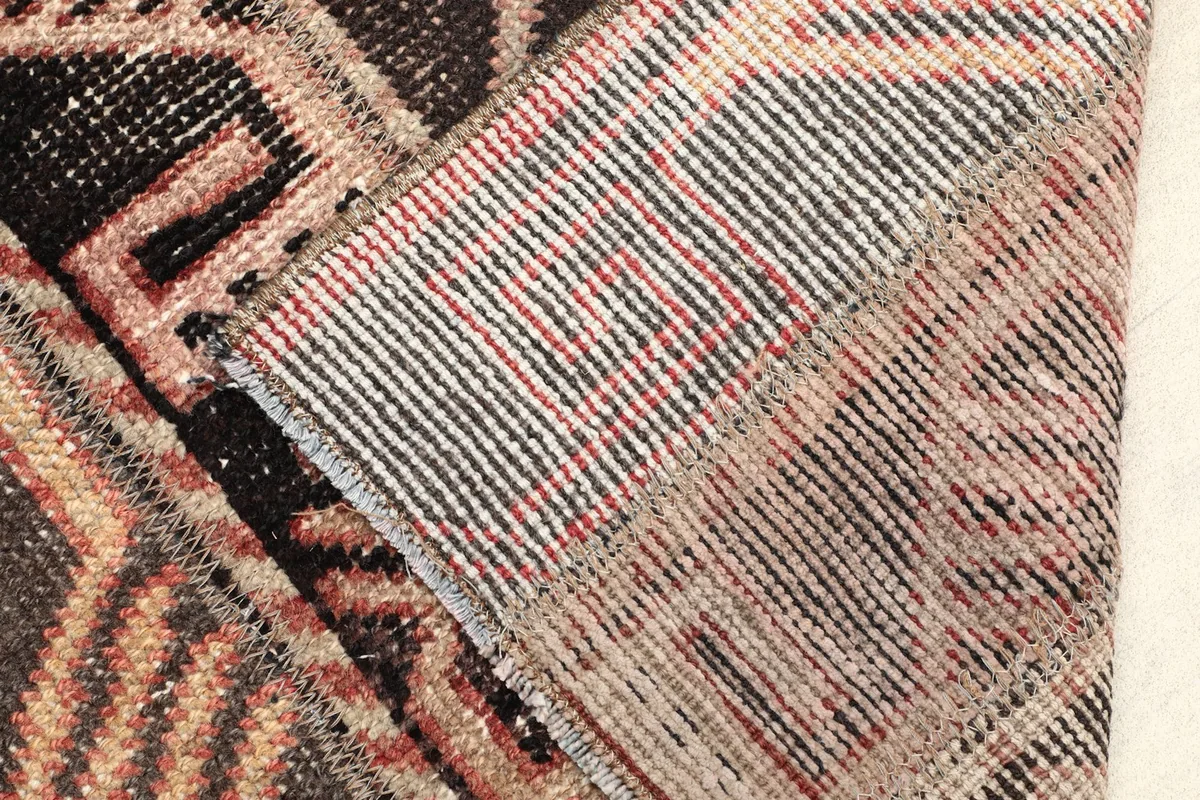 Close-up of the rug's reverse side, revealing the cotton foundation and hand-knotted construction.