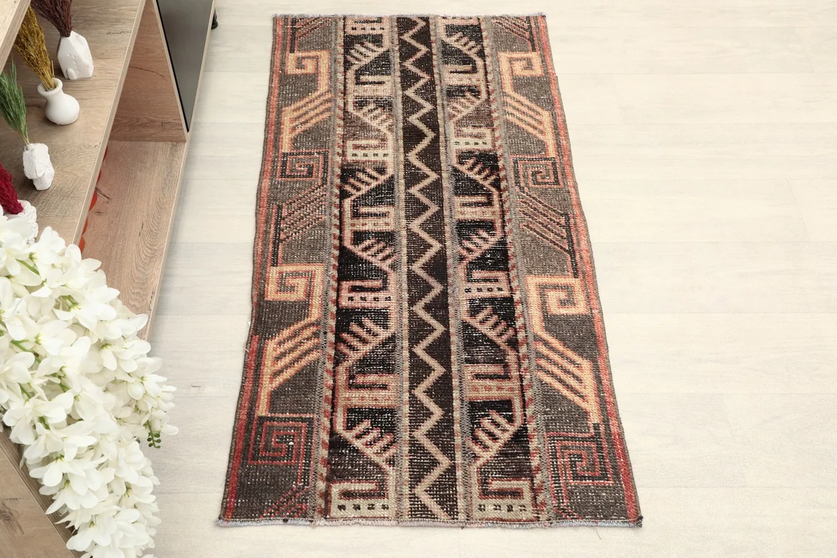 Overhead view of the rug, highlighting its brown, beige, and black geometric design.