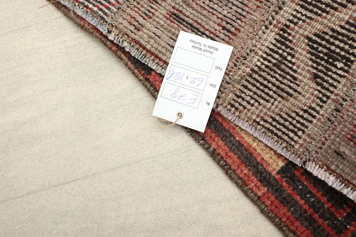 Back of the rug with a label, indicating its origin and hand-knotted quality.