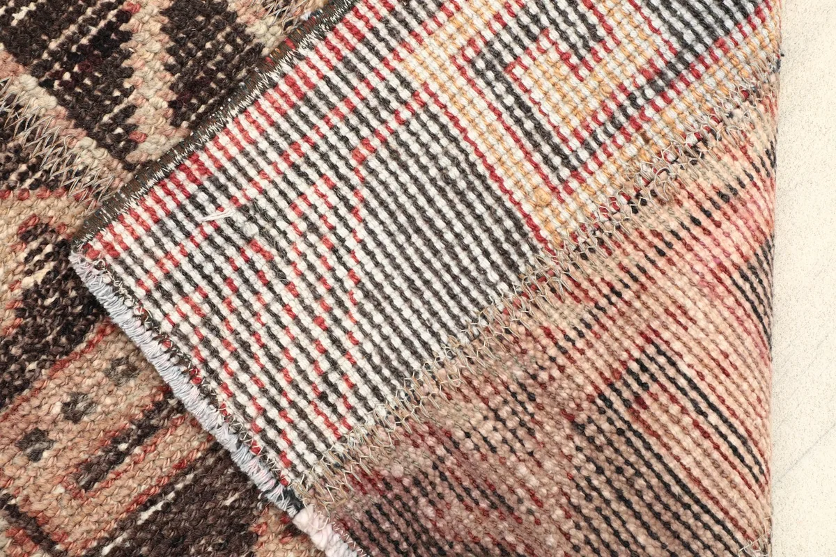 View of the back of the hand-knotted rug, revealing the tightly woven cotton foundation and knot structure.