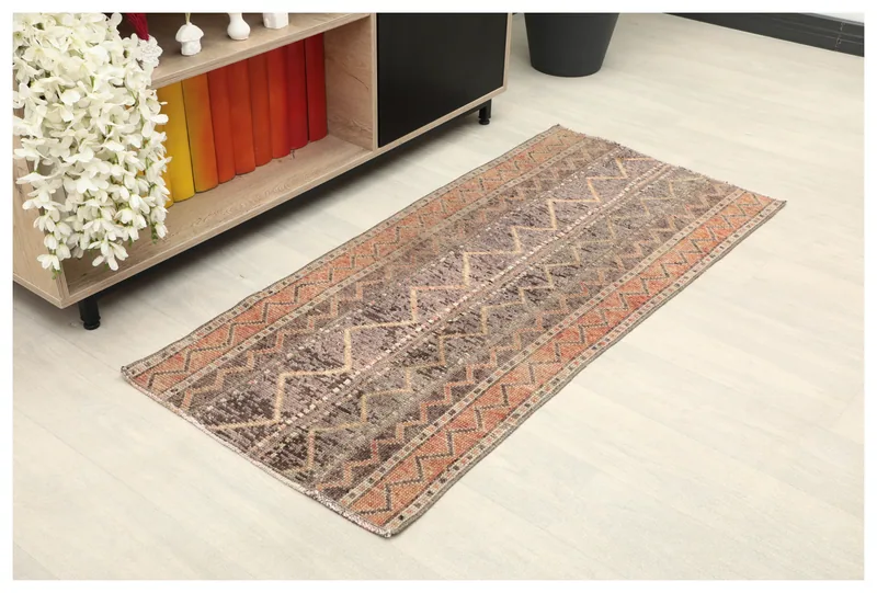 Full overhead view of the 2x5 vintage brown and rust tribal Anatolian rug on a white background.