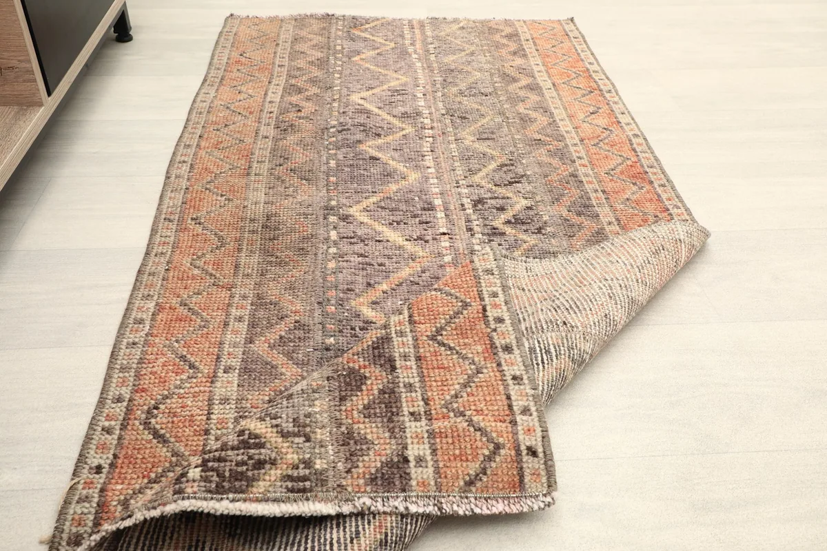 The rug partially rolled, showcasing its flexibility and the texture of the reverse side.
