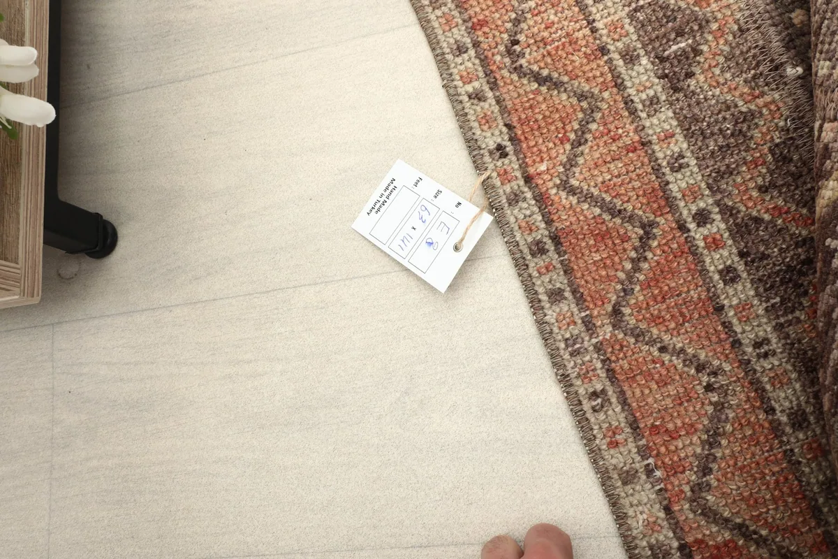 Corner of the rug with a size tag, providing context for its dimensions.