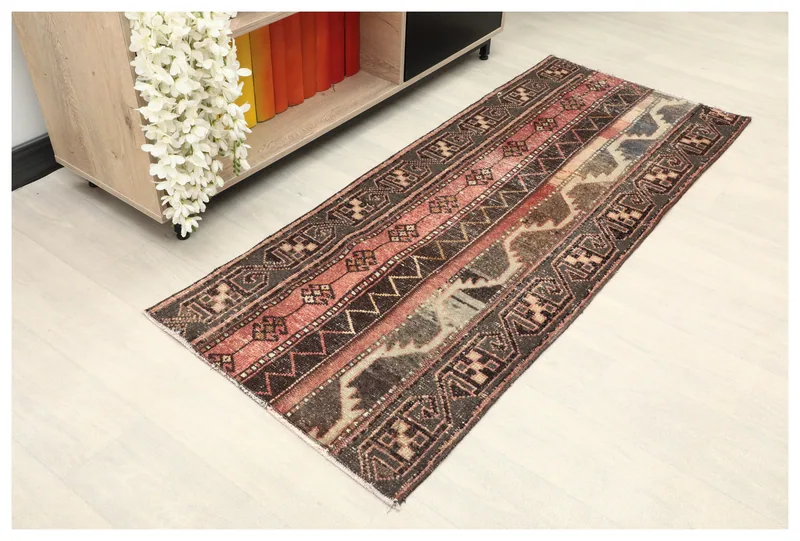 Full overhead view of the rust, brown, and gray-blue striped vintage Anatolian runner rug