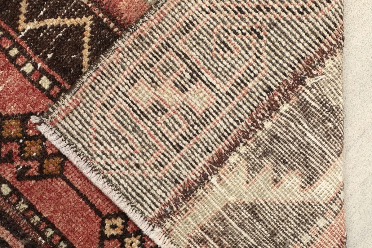 View of the rug's reverse side, showing the hand-knotted cotton foundation