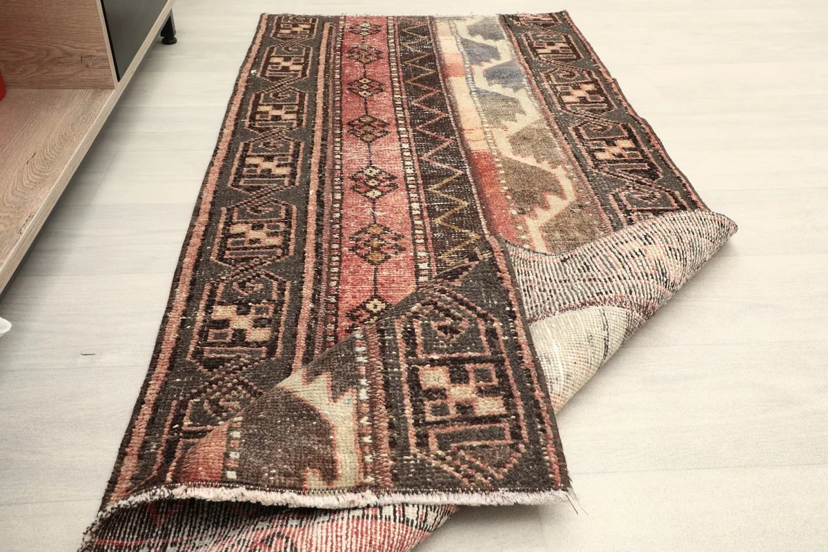 Rug partially folded, displaying both the pile and the foundation, in a room setting
