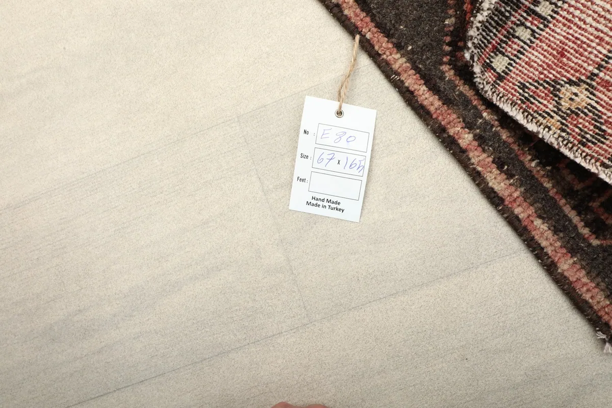 Close-up of the rug's care tag with size information and 'Hand Made in Turkey'