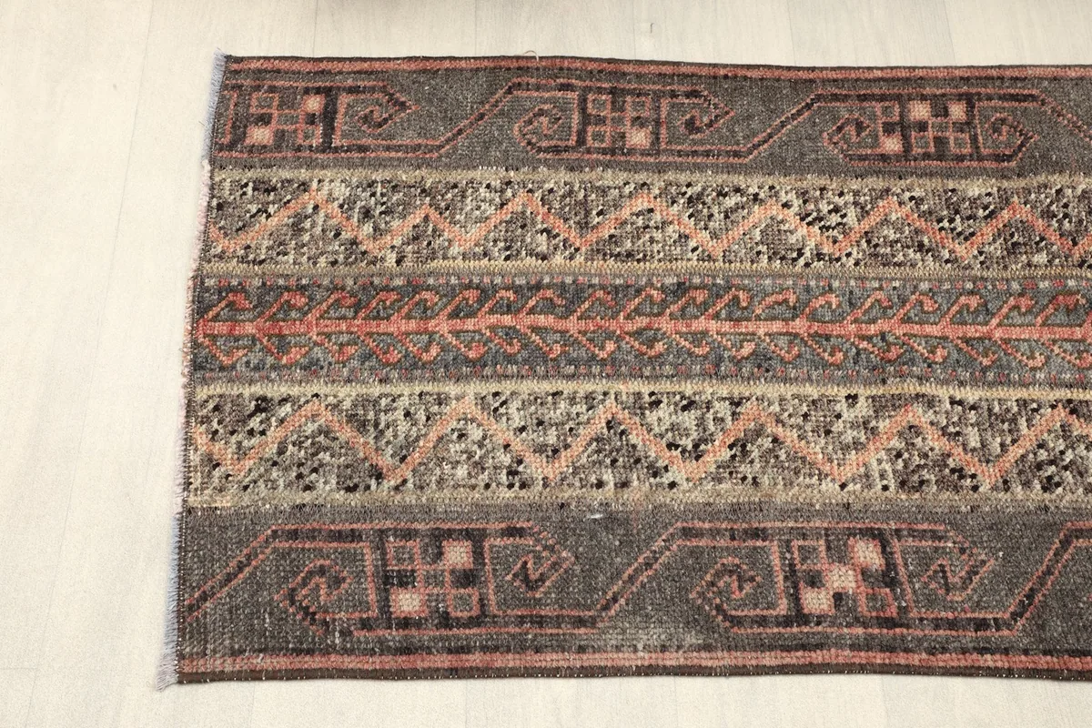 Partial view of the rug's width, displaying the distinct striped bands and their motifs.