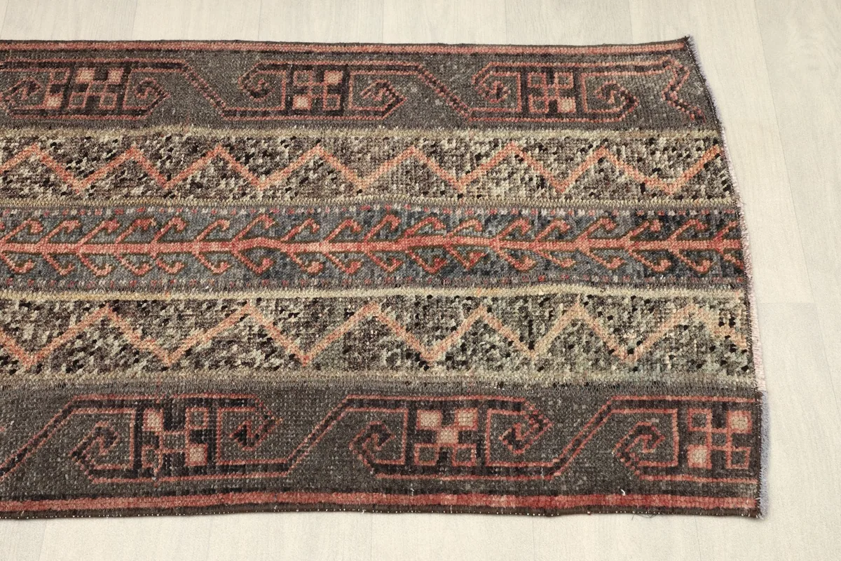 Another partial view from an angle, showing the consistent geometric patterns on the gray and rust bands.
