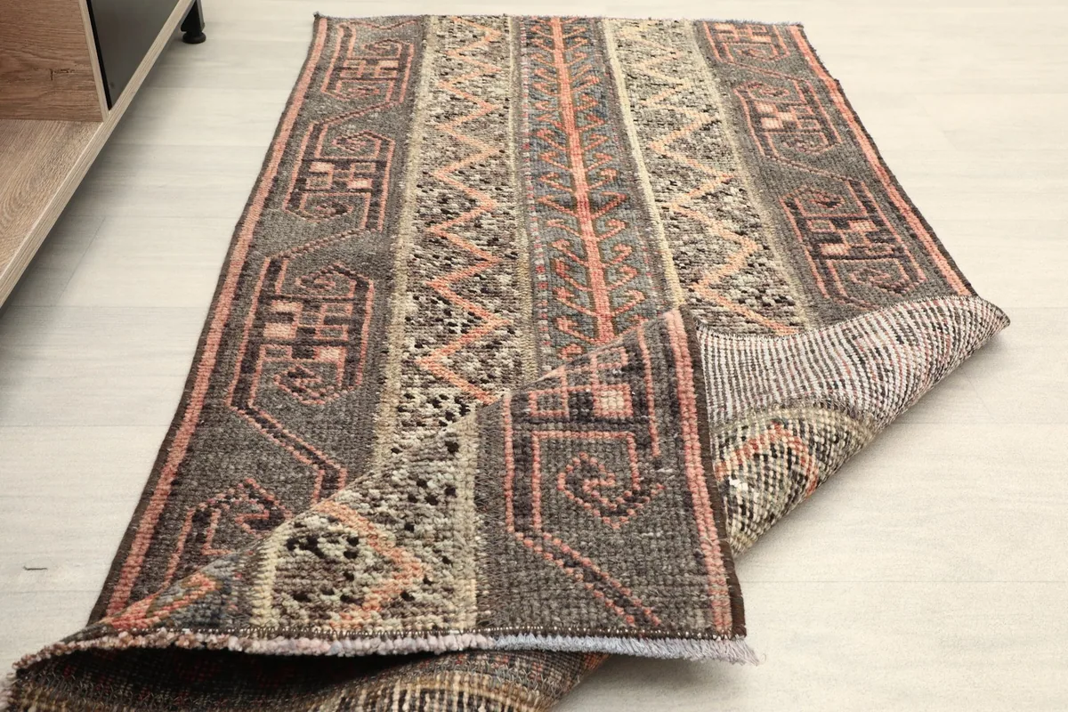 Rug folded back on itself, revealing the pile texture and the tightly woven foundation.