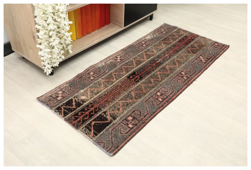 Full top view of the vintage gray and rust geometric runner rug on a white background
