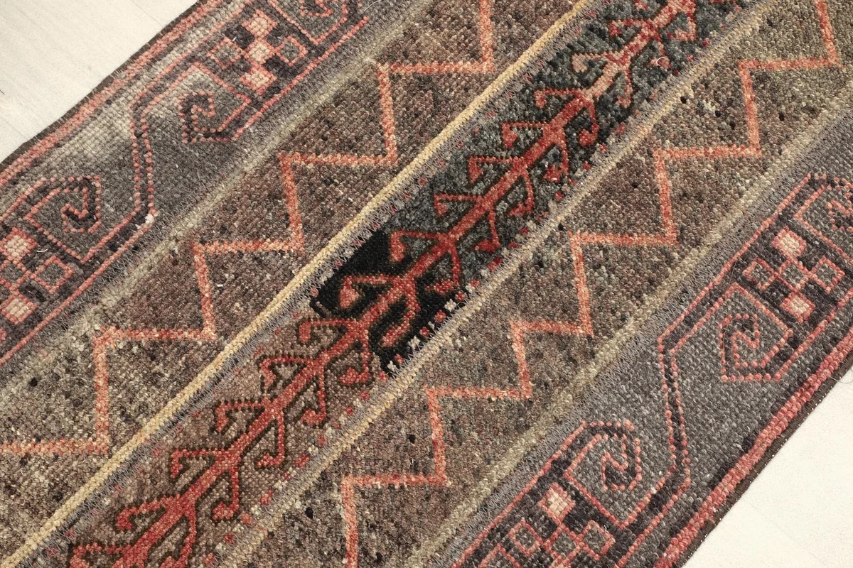Angled view highlighting the varied gray, rust, and black geometric patterns