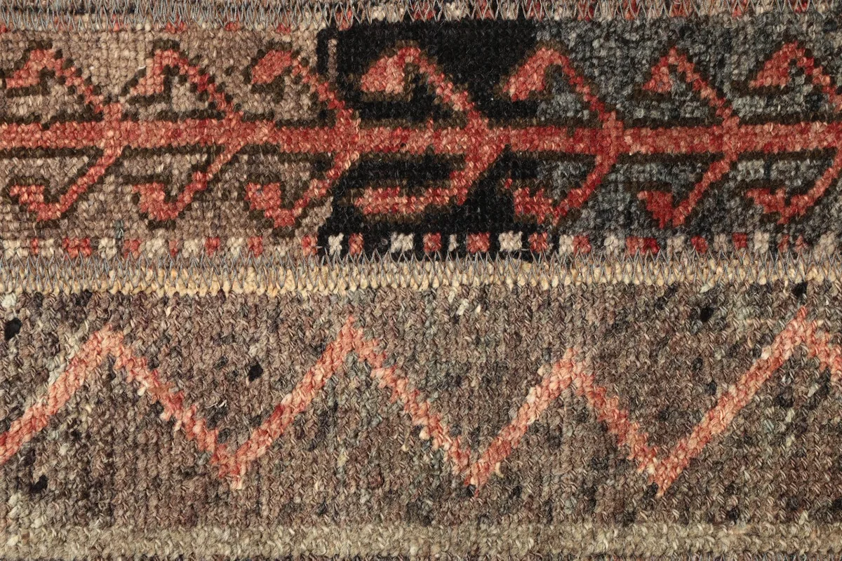 Detailed view of the rug's tribal motifs and color variations within the pile