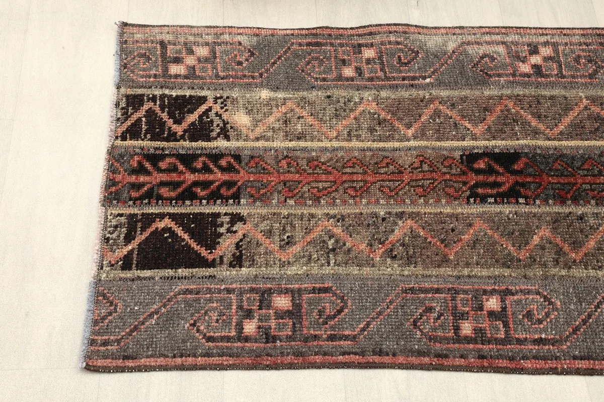 View of the rug's border and central striped design from one end