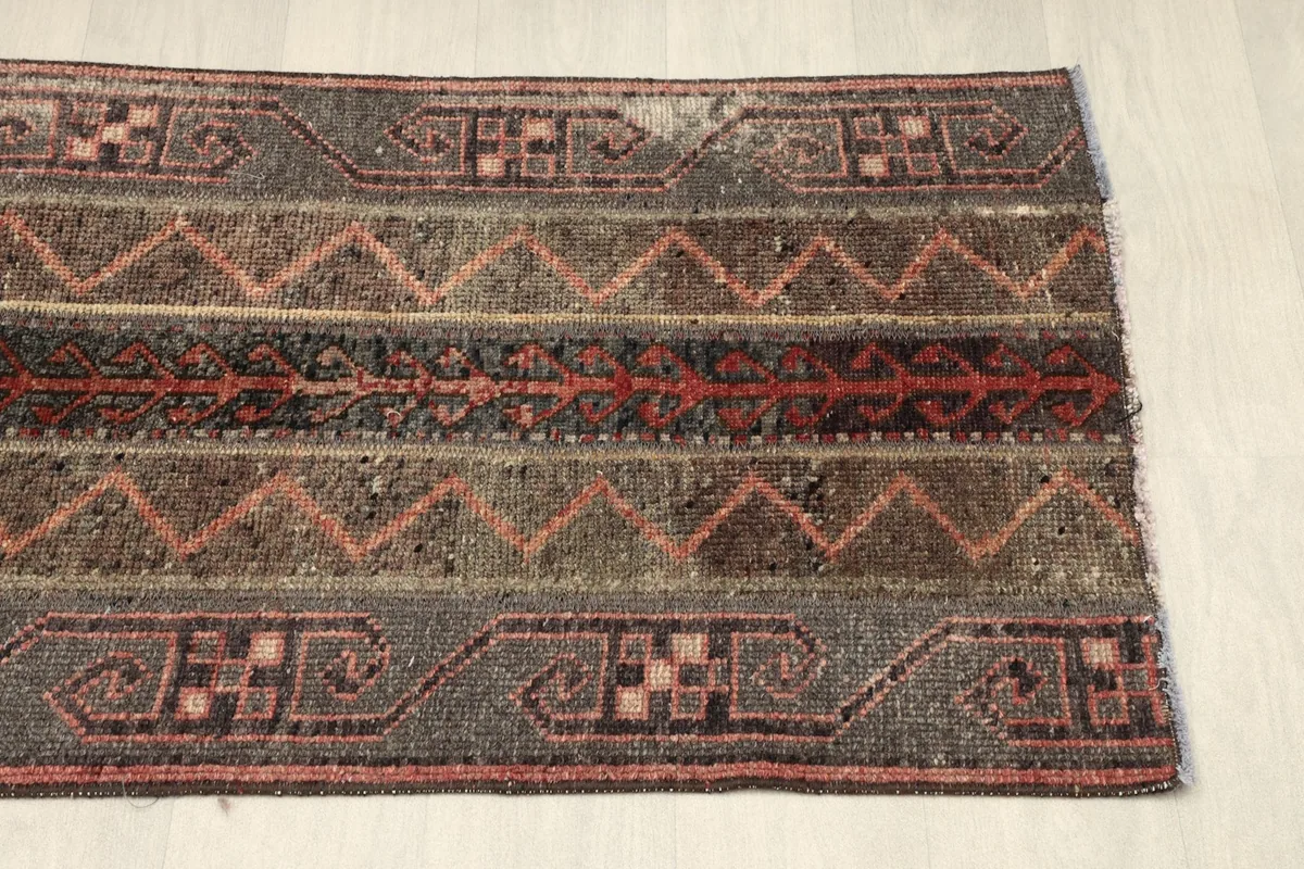 View of the rug's border and central striped design from the opposite end