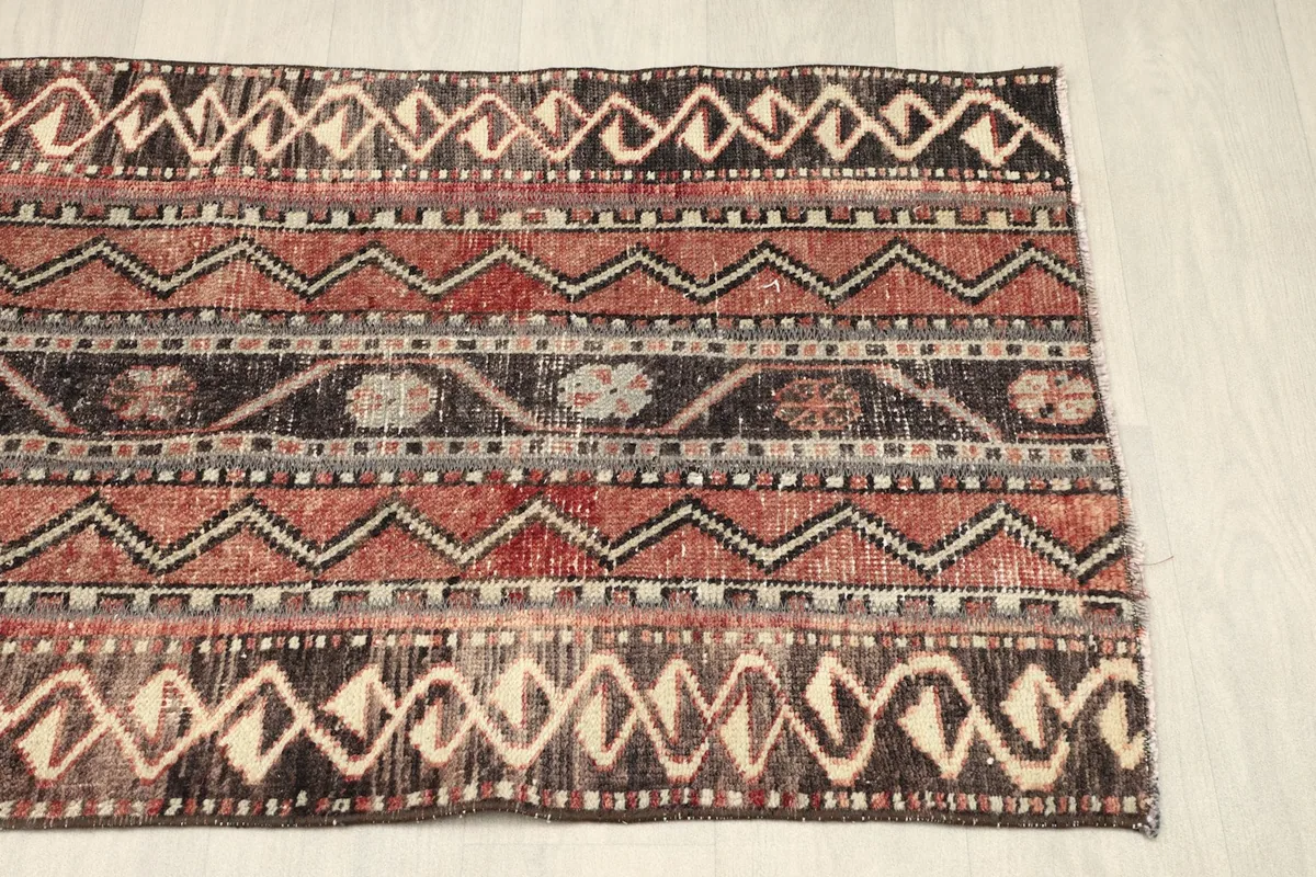 View of the rug from the opposite side, showcasing the full spectrum of its vintage patterns.