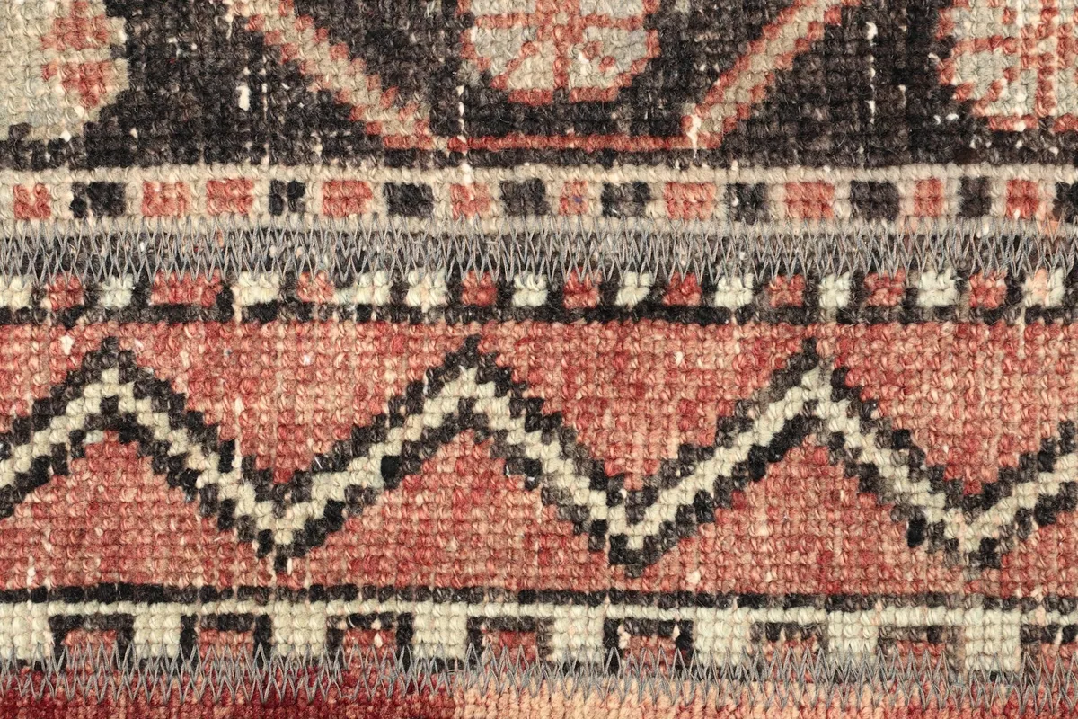 Detailed shot of the rug's central design elements, including zigzag and floral-like patterns.