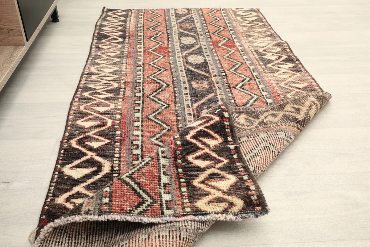 The rug partially folded, illustrating its flexibility and the consistent pattern from top to underside.