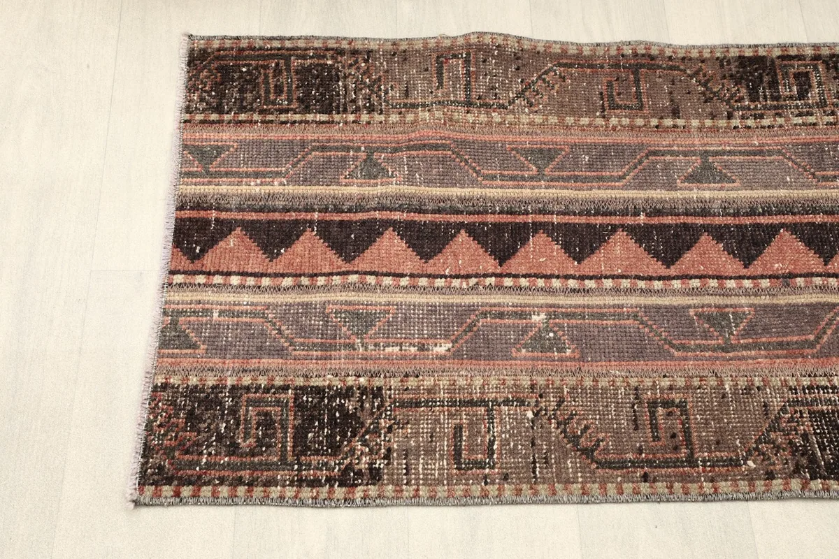 Partial view of the rug from one end, showing the rich color variations and geometric details.