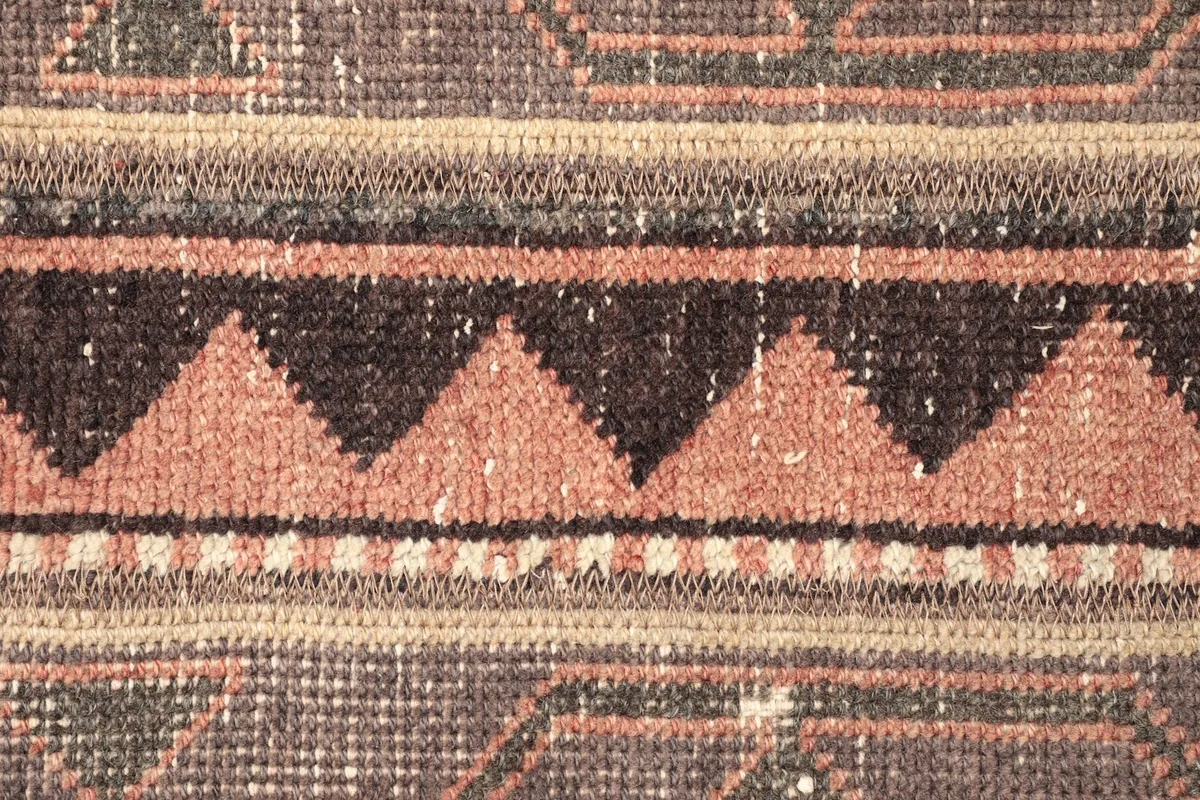 Detailed shot of the central striped design with prominent rust and black triangle motifs.