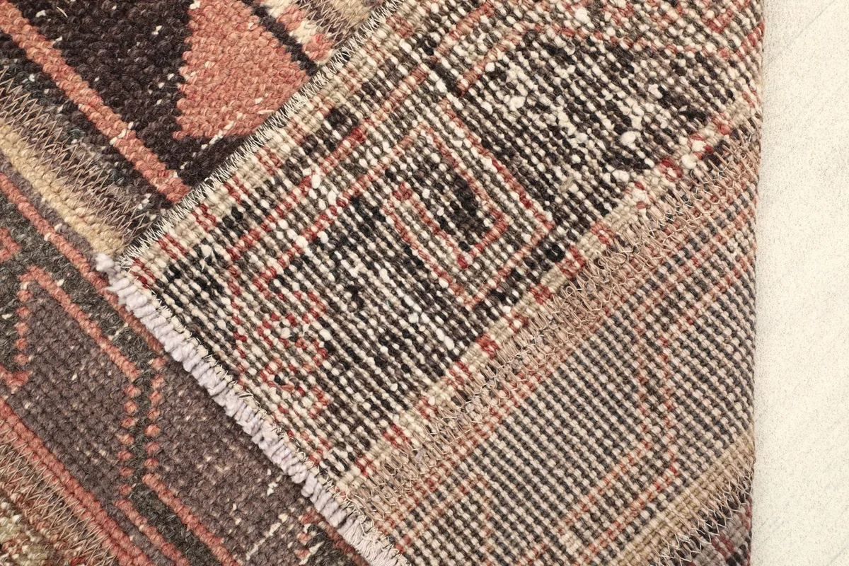 View of the rug's backside, revealing the cotton foundation and the tightly woven hand-knotted construction.