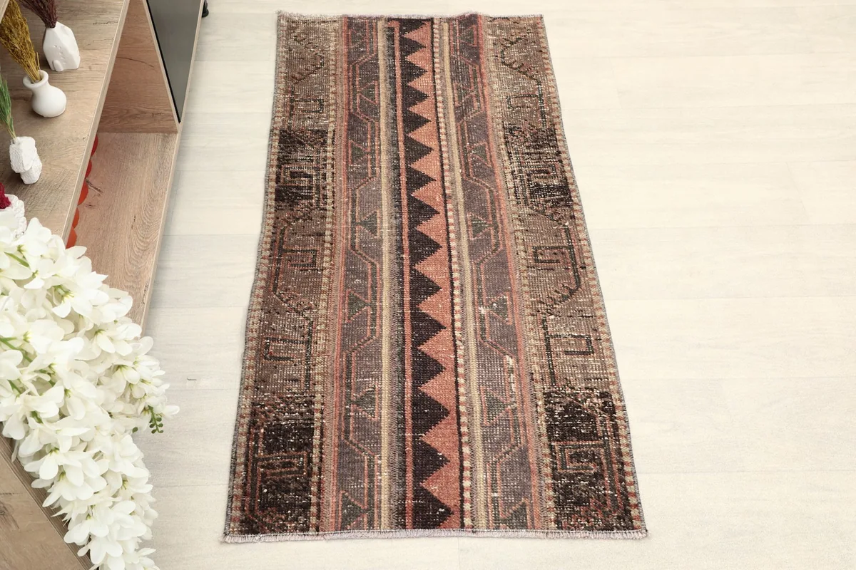 Overhead view of the hand-knotted rug, highlighting its full pattern and distressed character.