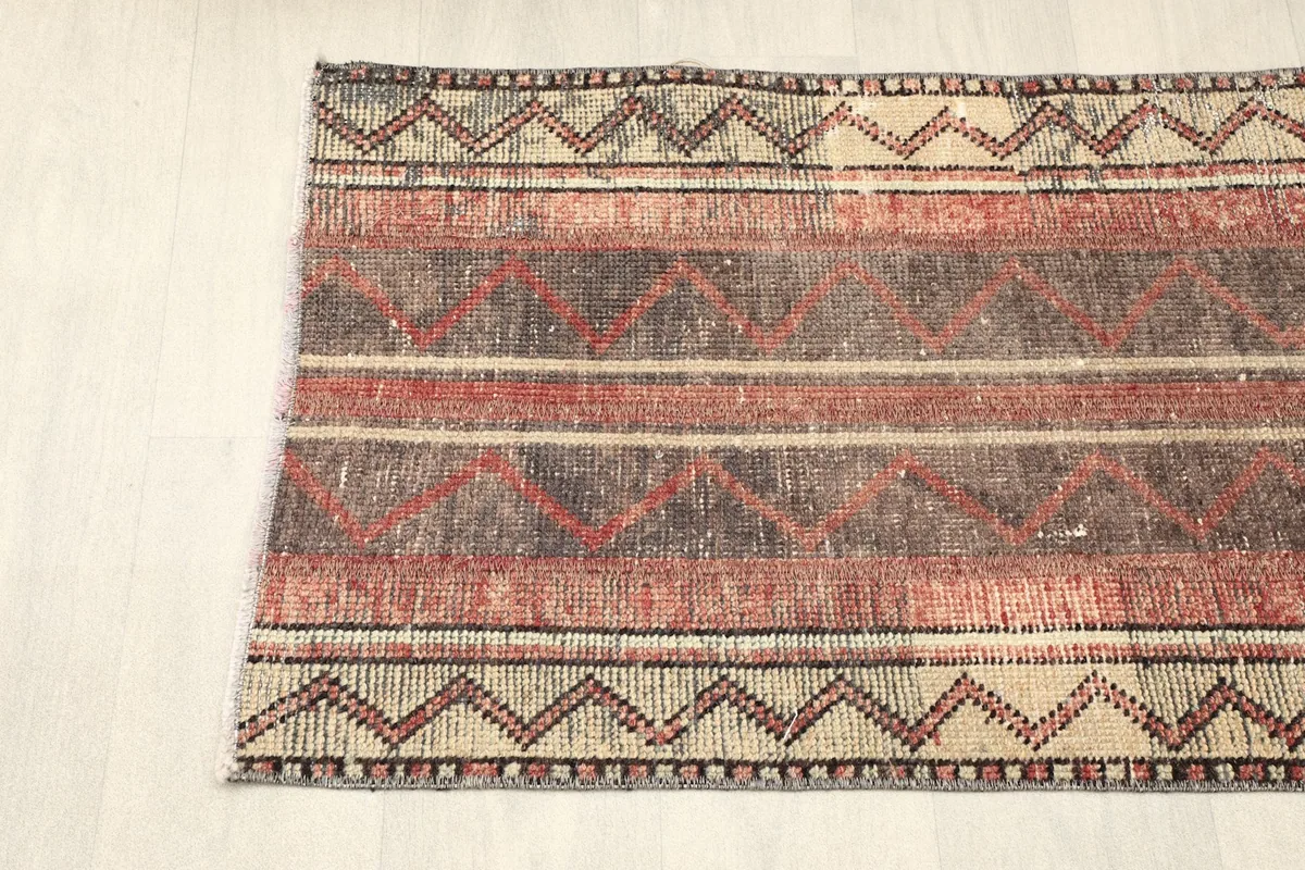 Partial top-down view of the rug, focusing on the distinct striped and zigzag patterns.