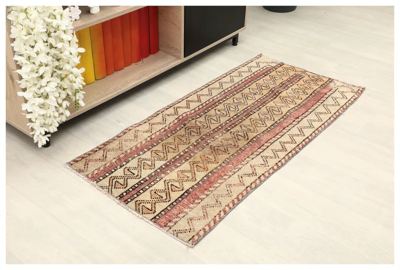 Full top view of the beige and rust vintage Anatolian rug on a white floor