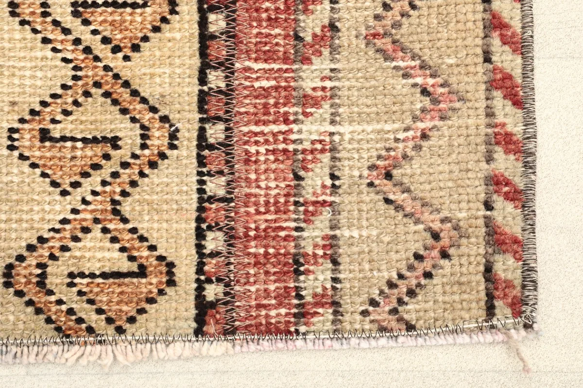 Close-up of the rug's edge showing hand-knotted wool pile and fringe