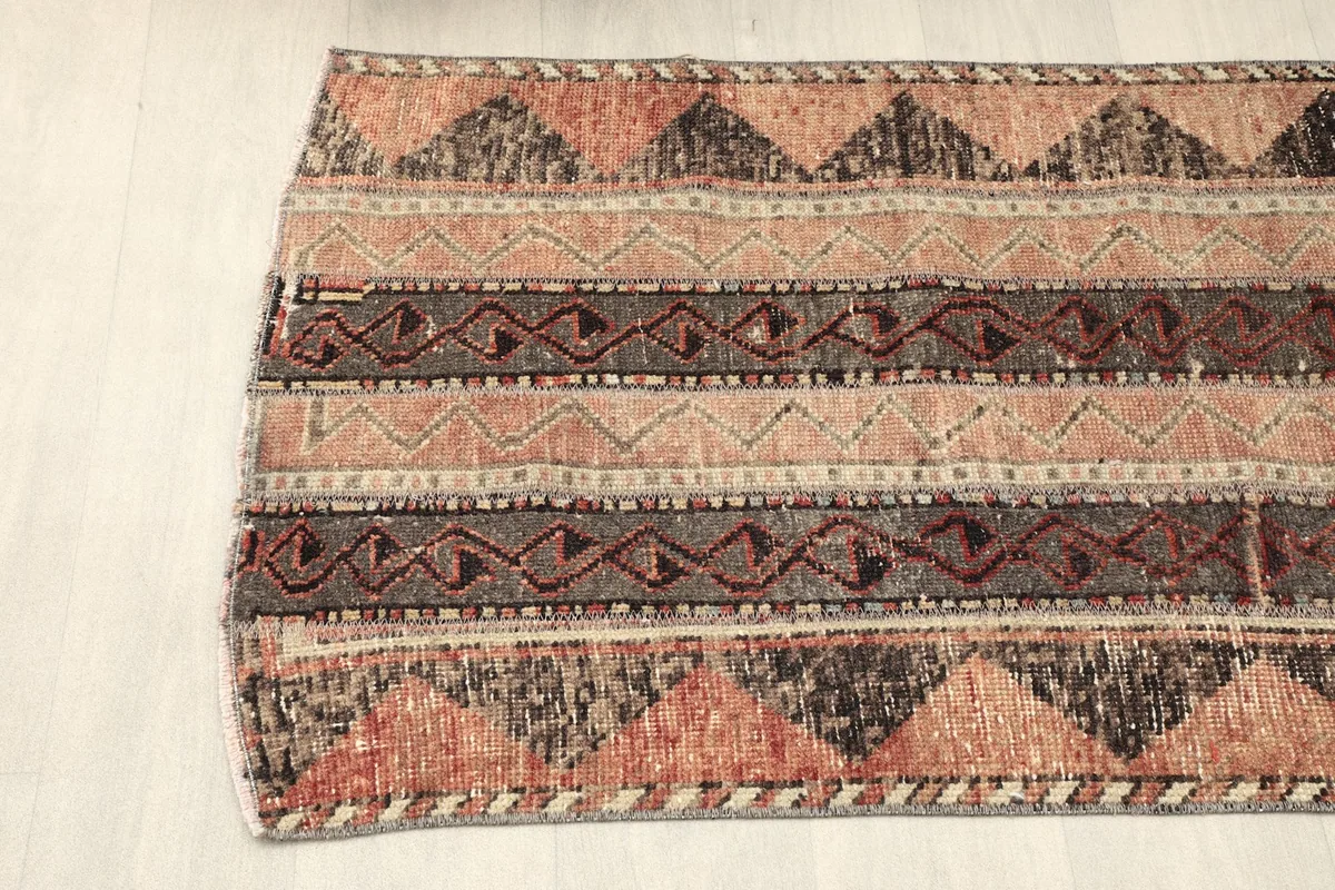 Angled shot of the rug's middle section, showing the consistent striped pattern and natural wear.