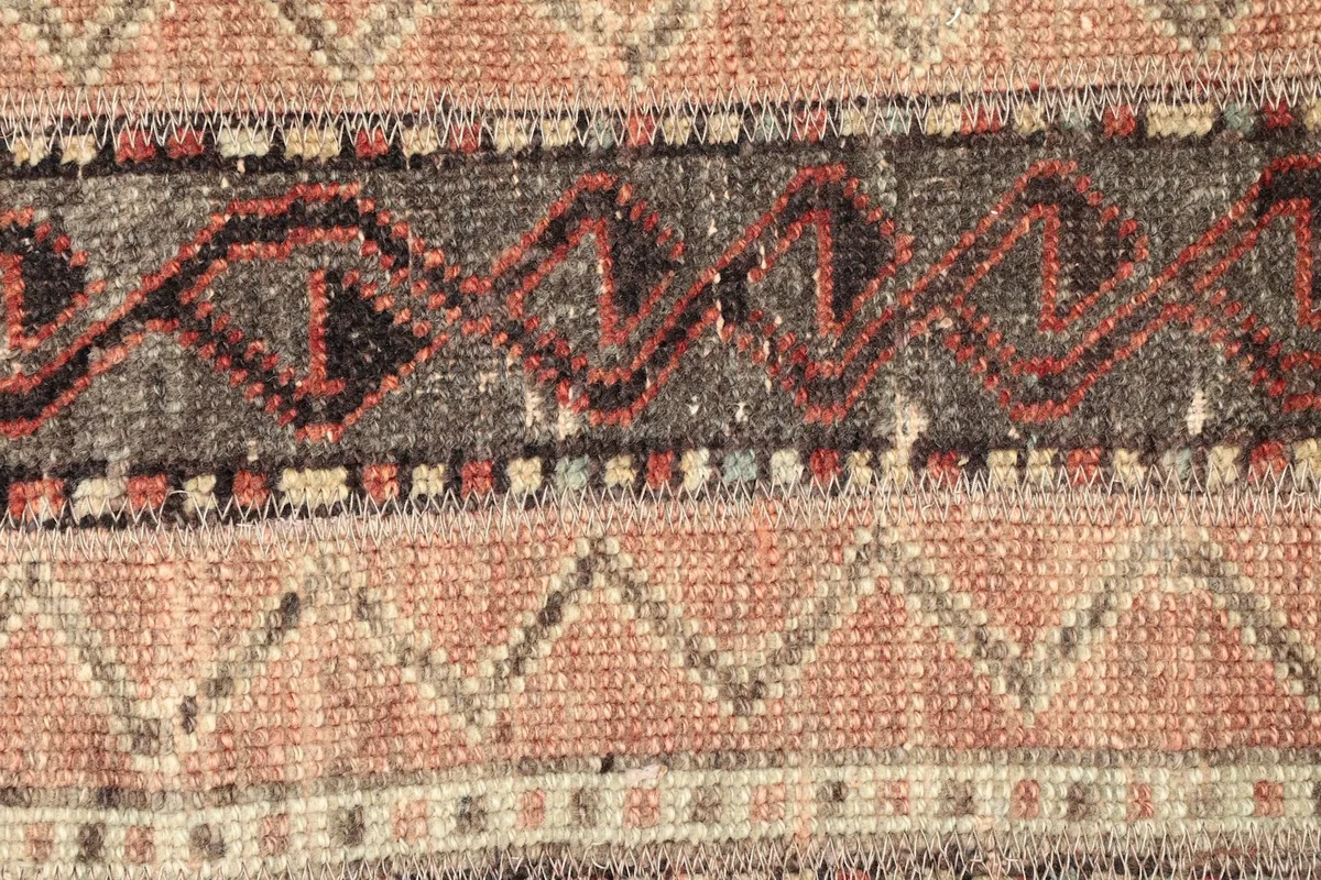 Detailed view of the intricate tribal geometric motifs and color blend in the rug's central stripes.