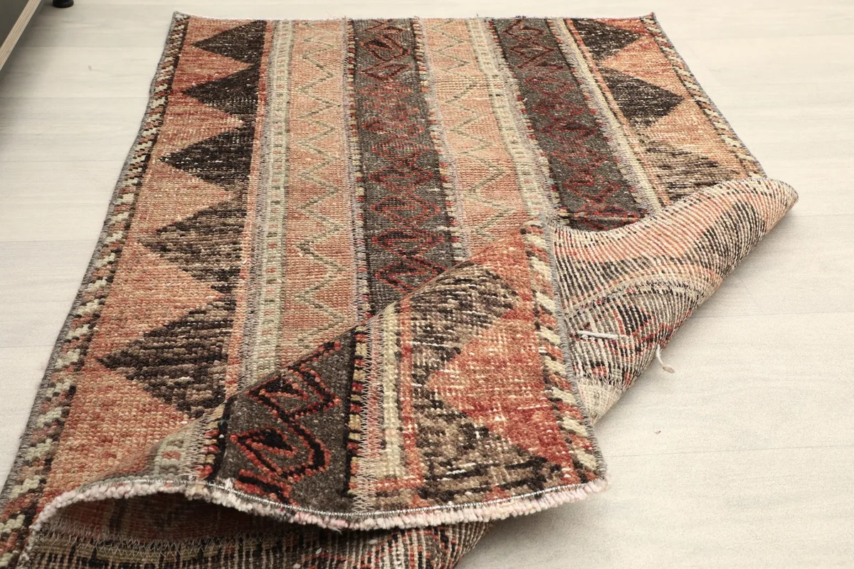 Rug partially folded, demonstrating its pliable nature and the thickness of the wool pile.