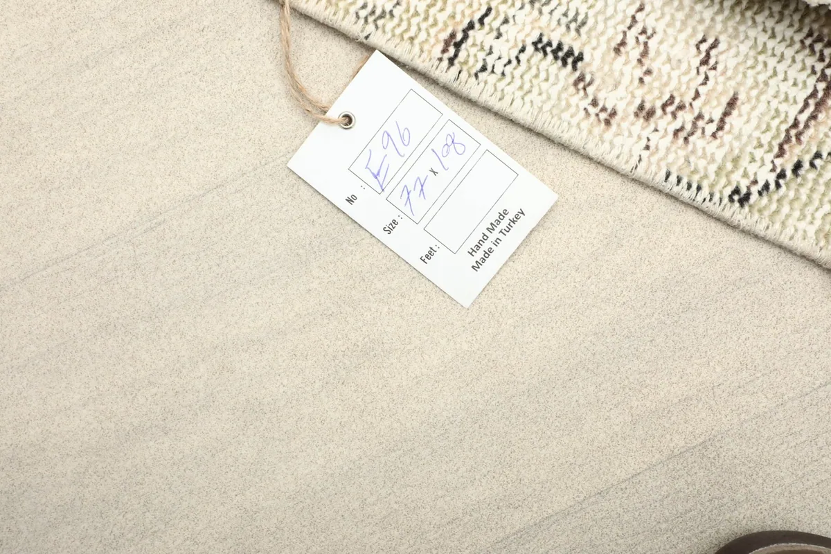 Product tag displaying the rug's dimensions and origin, next to the folded rug