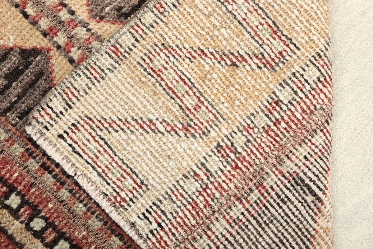 View of the back of the rug, revealing the intricate hand-knotted cotton foundation