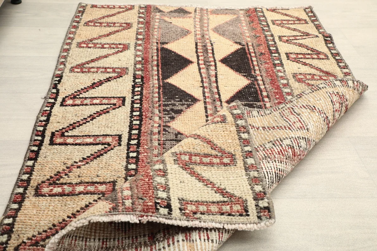 Rug partially folded, demonstrating its flexibility and the hand-knotted construction