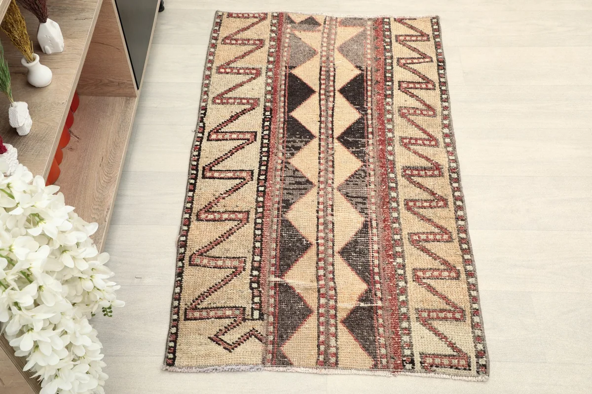 Overhead view showcasing the full length and width of the beige and black tribal rug
