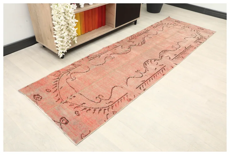 Full top view of the 2'6" x 8'0" rose tribal Anatolian runner rug on a white floor.