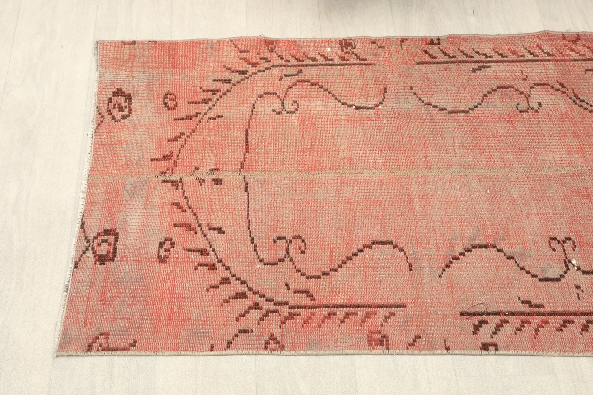 View of the runner's side with its faded rose field and brown tribal border-like elements.