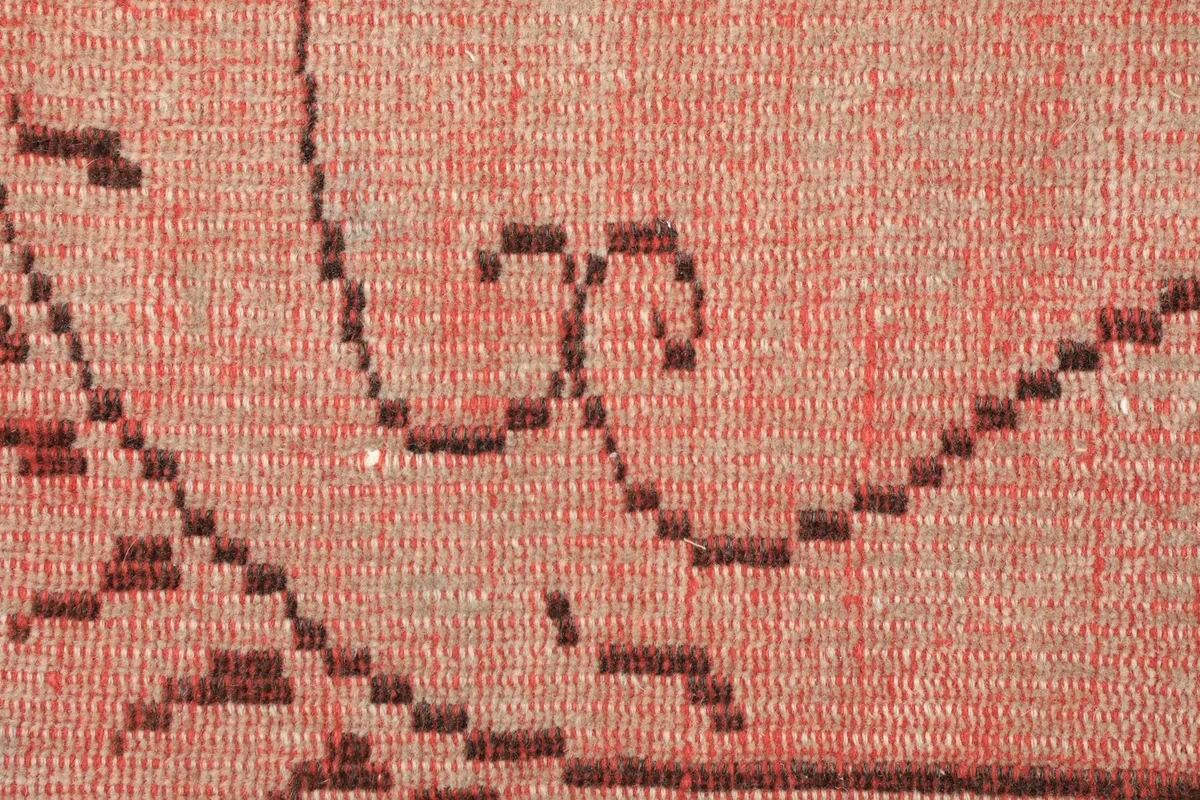 Detailed view of the low wool pile texture and hand-knotted construction of the rug.