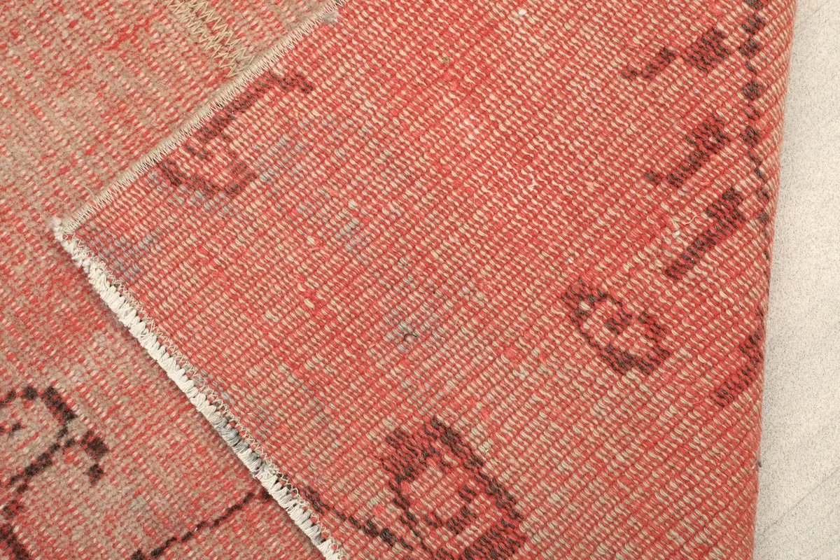 Close-up of a corner folded back, revealing the rug's thickness and reverse side.