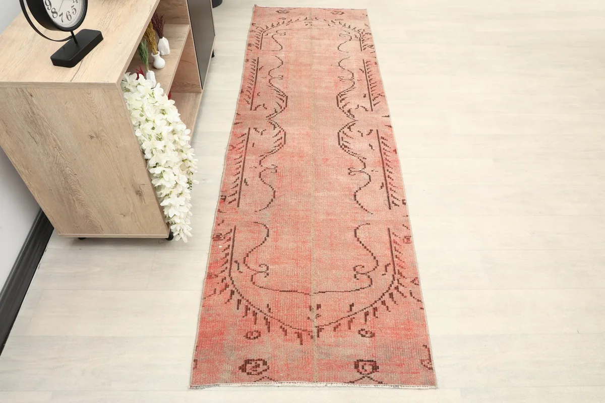 Overhead view of the vintage rose runner rug, showing its full length and tribal patterns.