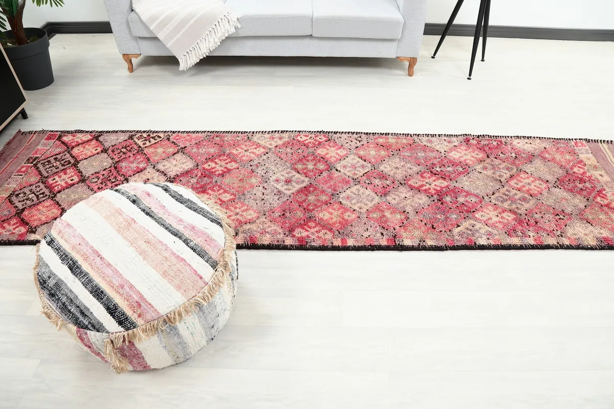 Wide shot of the room with the rose geometric runner rug as a central feature