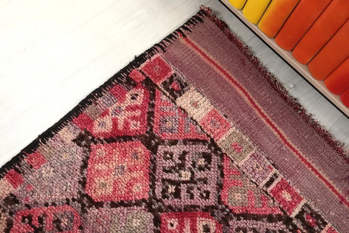 Corner detail showing the distinct pattern of the rug and the edge finishing