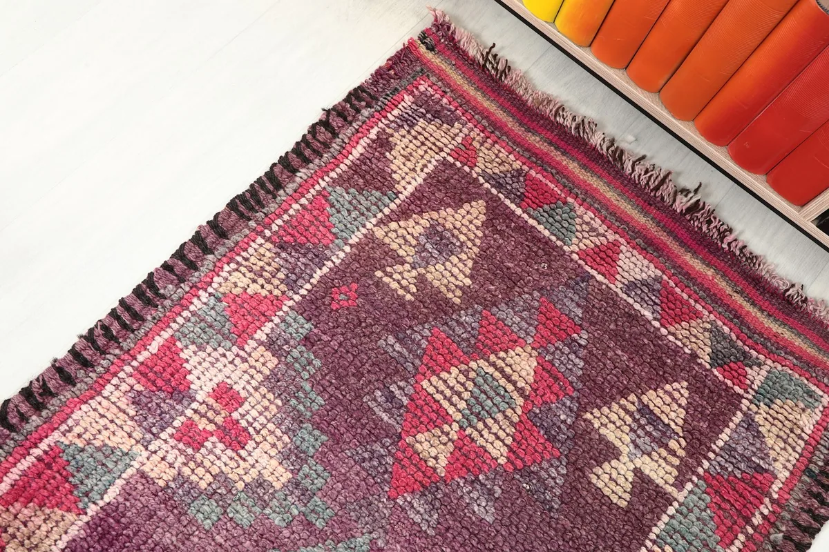 Close-up angled view of the rug's patterns and the subtle color shifts in the wool.