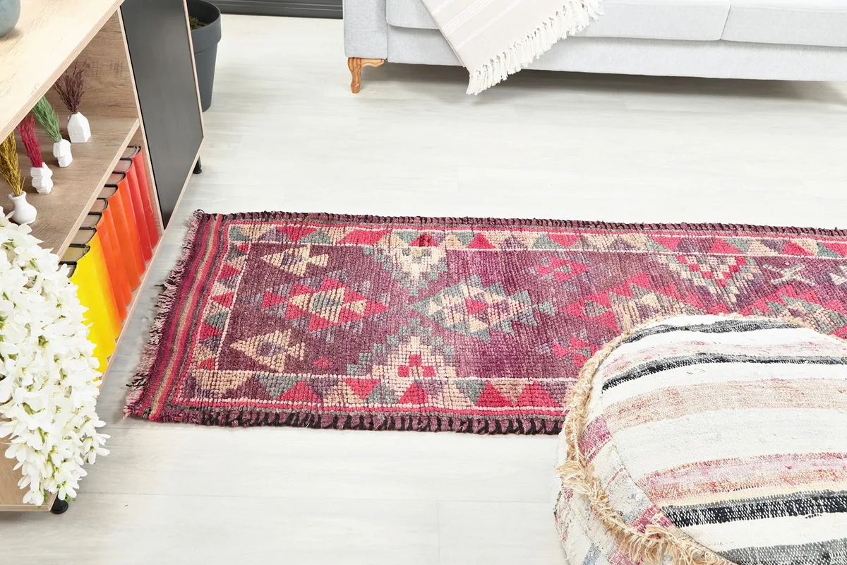 View of the purple runner rug extending across a hallway next to a seating area.