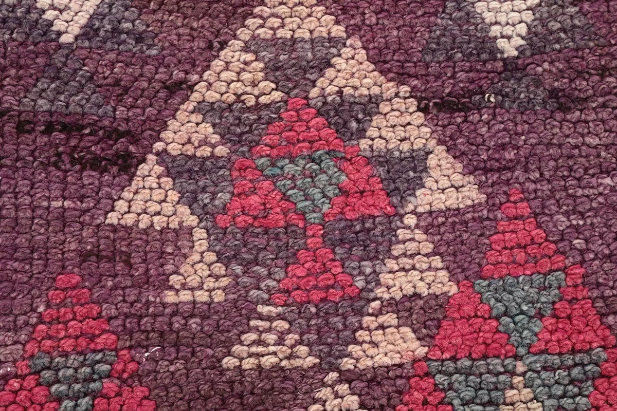 Extreme close-up of the hand-knotted wool pile, revealing individual knots and color variations.