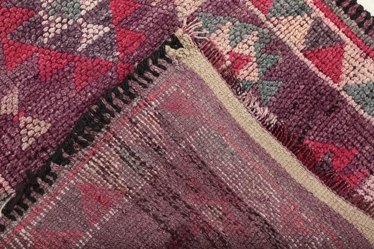 View of the back of the hand-knotted wool rug, showing the cotton foundation and knotting.