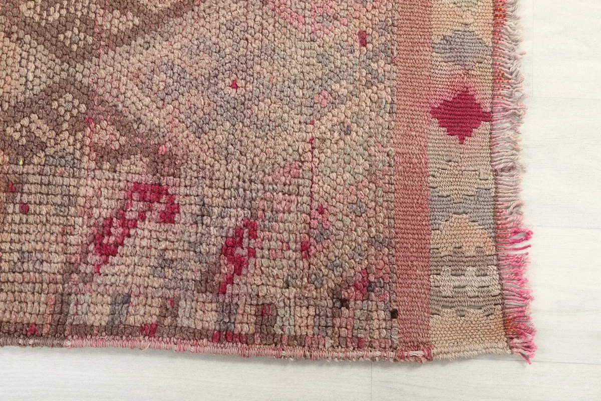 Detailed view of the rug's edge, showing the hand-knotted texture and a section of fringe.