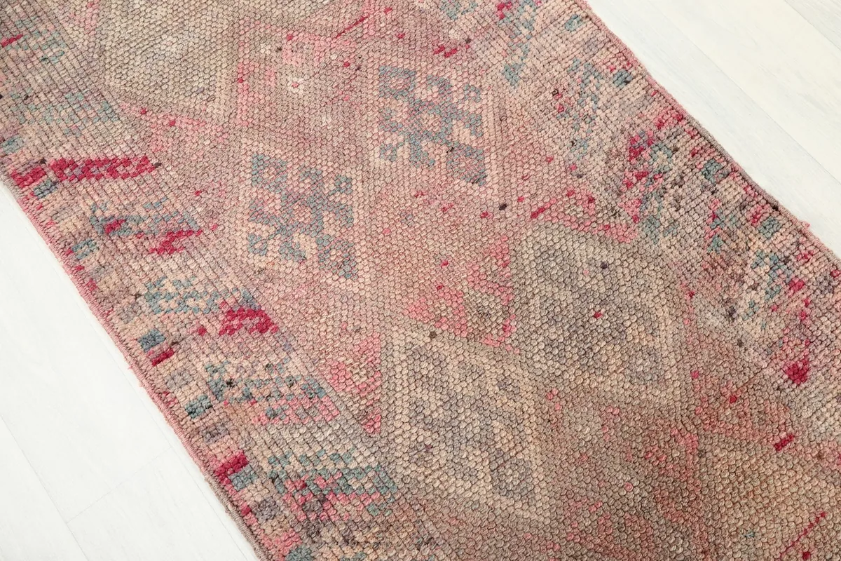 Close-up of the rose and gray geometric patterns and the low wool pile.